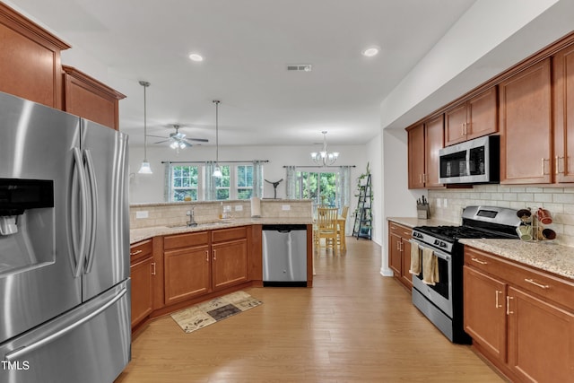 416 Durants Neck Ln, Morrisville, NC 27560 - kitchen featuring stainless steel appliances, a sink, a peninsula, backsplash, and light wood-type flooring