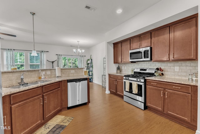 416 Durants Neck Ln, Morrisville, NC 27560 - kitchen featuring stainless steel appliances, a sink, decorative backsplash, light wood-type flooring, and healthy amount of natural light