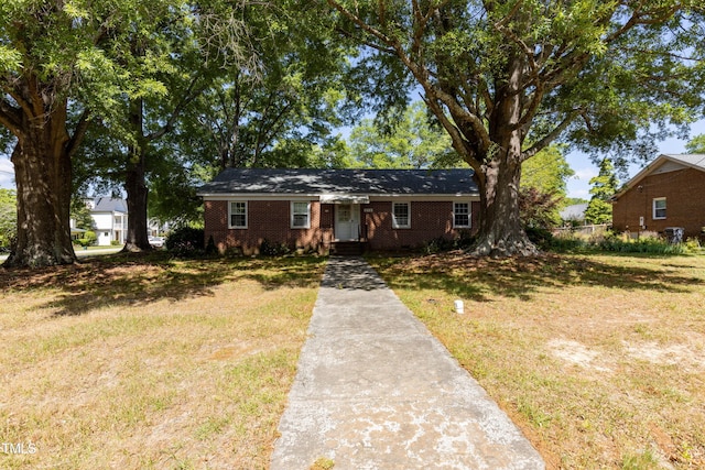view of front facade with concrete driveway, brick siding, and a front lawn