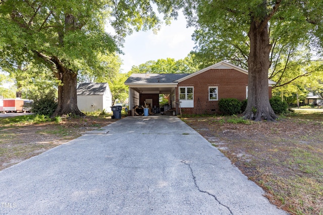 single story home with a carport, brick siding, and driveway