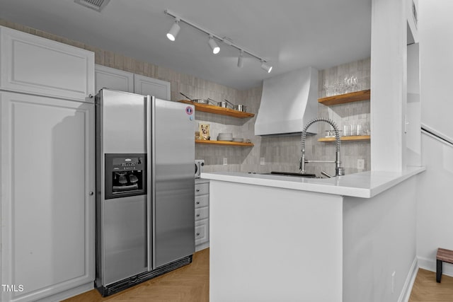 320 W Martin St Unit 205, Raleigh, NC 27601 - kitchen with open shelves, stainless steel refrigerator with ice dispenser, wall chimney exhaust hood, backsplash, and a peninsula