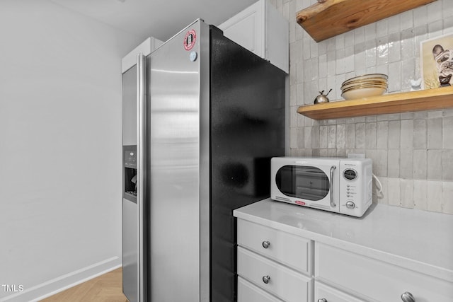 320 W Martin St Unit 205, Raleigh, NC 27601 - kitchen with white microwave, stainless steel refrigerator with ice dispenser, light countertops, and white cabinets