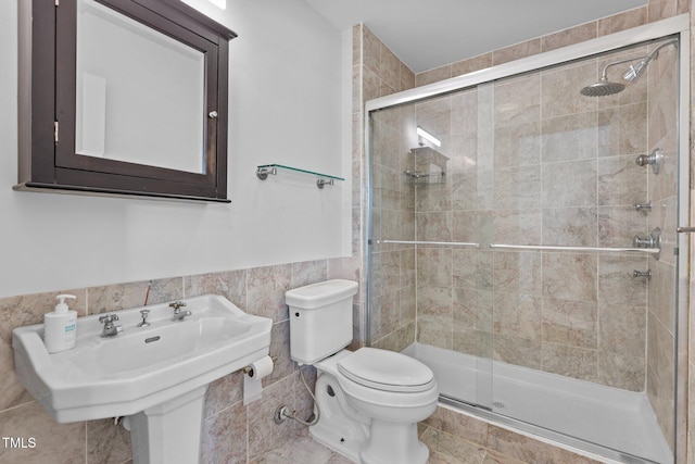 320 W Martin St Unit 205, Raleigh, NC 27601 - bathroom with a shower stall, toilet, tile walls, a sink, and wainscoting