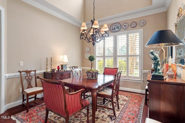 dining room with healthy amount of natural light, a chandelier, wood finished floors, baseboards, and ornamental molding