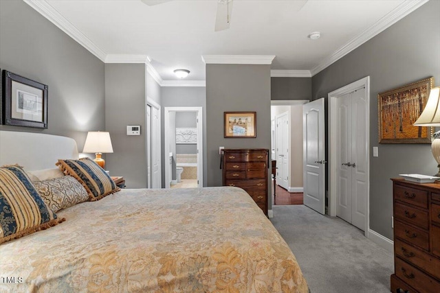 bedroom with carpet, ornamental molding, multiple closets, baseboards, and ensuite bath