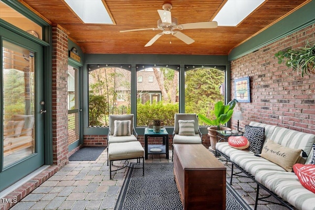 sunroom / solarium featuring a skylight, an outdoor living space, and a ceiling fan