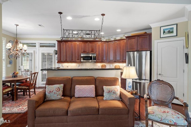 living area featuring wood finished floors, ornamental molding, a chandelier, and recessed lighting