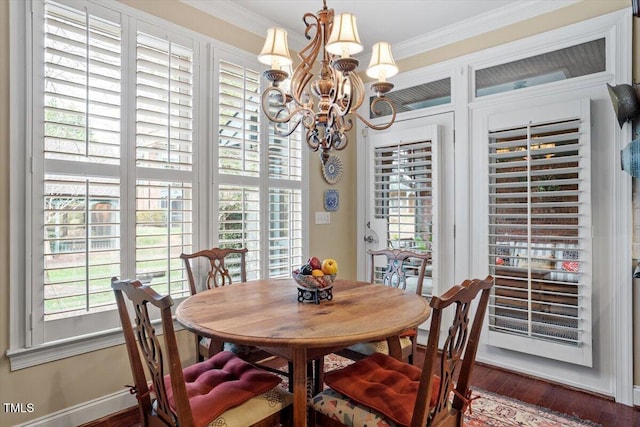 dining area with a chandelier, crown molding, dark wood finished floors, and baseboards