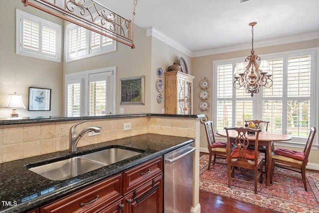 kitchen with dishwasher, a sink, a chandelier, dark wood finished floors, and baseboards