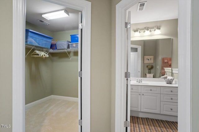 bathroom with a spacious closet and vanity