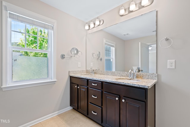 full bathroom featuring tile patterned floors, double vanity, and baseboards