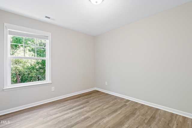 spare room featuring wood finished floors and baseboards