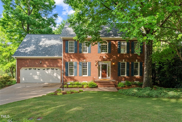 colonial house with concrete driveway, brick siding, a front lawn, a garage, and roof with shingles