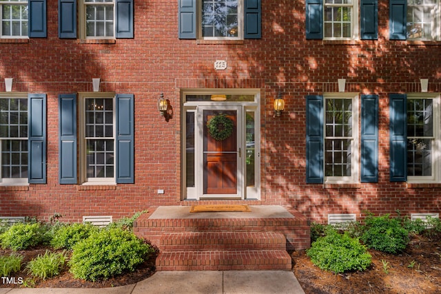 doorway to property featuring brick siding