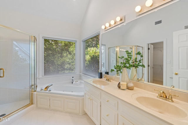 full bathroom featuring a shower stall, a bath, double vanity, tile patterned floors, and a spacious closet