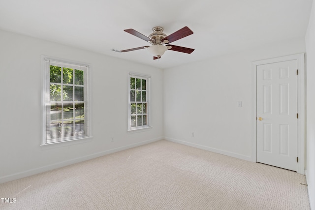 spare room with carpet flooring, a ceiling fan, and baseboards