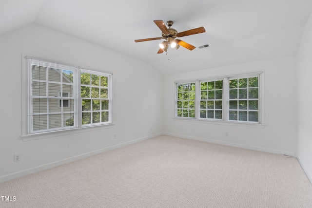 carpeted empty room with vaulted ceiling, plenty of natural light, a ceiling fan, and baseboards