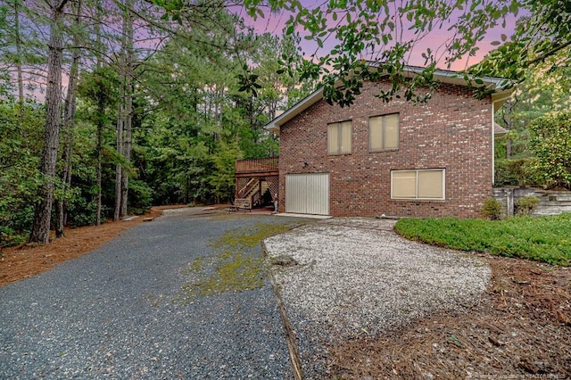 241 Firetree Ln, West End, NC 27376 - property exterior at dusk with a deck, stairs, and brick siding