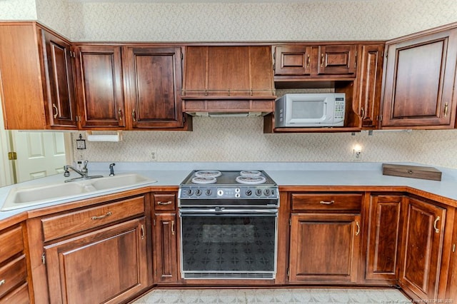 241 Firetree Ln, West End, NC 27376 - kitchen featuring wallpapered walls, a sink, white microwave, light countertops, and range with electric stovetop