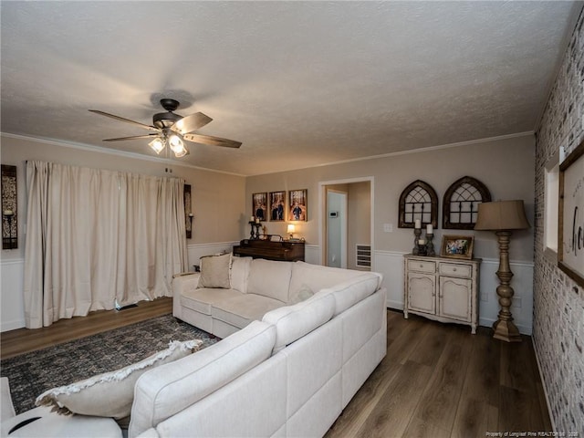 living room featuring a wainscoted wall, dark wood-style flooring, and a ceiling fan