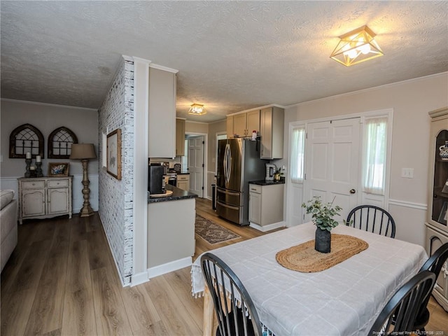 dining area with crown molding, a textured ceiling, and wood finished floors