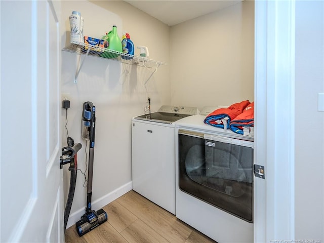 laundry room with laundry area, light wood-style flooring, baseboards, and washing machine and clothes dryer