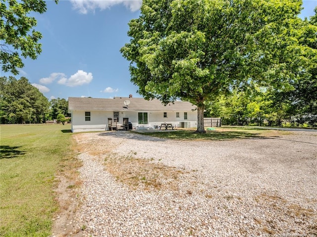 view of front of property featuring a front lawn and gravel driveway
