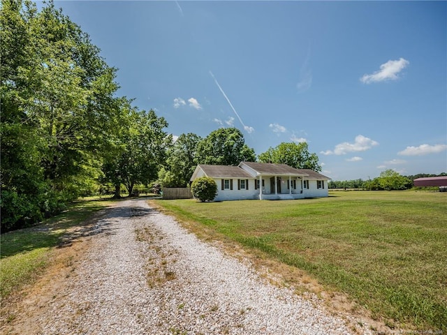 ranch-style home with fence, a front lawn, and gravel driveway