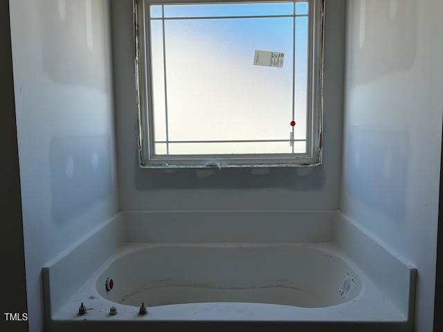full bathroom featuring plenty of natural light and a tub to relax in