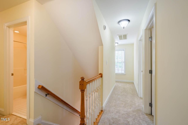 hallway featuring an upstairs landing, carpet flooring, and baseboards