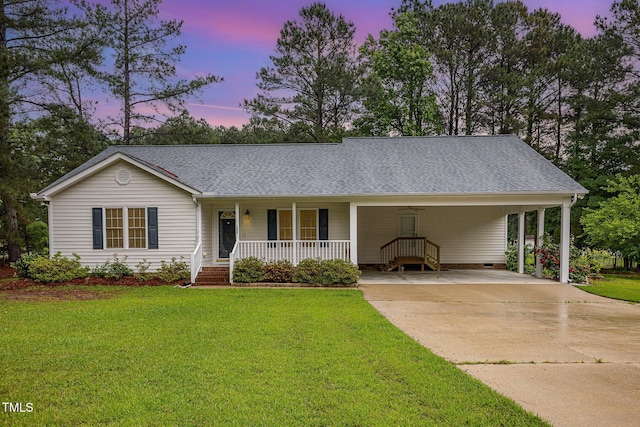 view of front of property featuring covered porch, driveway, a yard, and a shingled roof