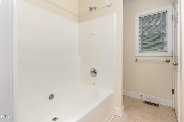 bathroom featuring baseboards, shower / washtub combination, and tile patterned flooring