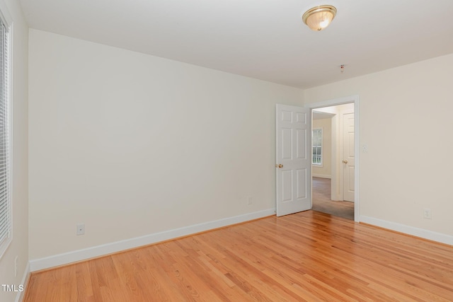 empty room with light wood-type flooring and baseboards