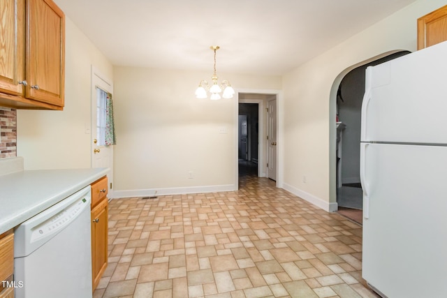 kitchen featuring white appliances, baseboards, a chandelier, light countertops, and arched walkways