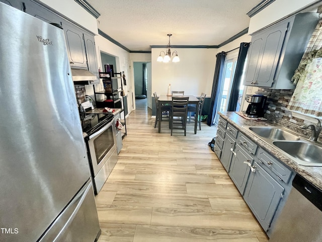 1305 Shakentown St, Knightdale, NC 27545 - kitchen featuring stainless steel appliances, a sink, ornamental molding, a chandelier, and light wood-type flooring