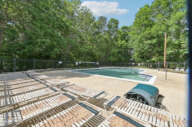 pool with a patio and fence