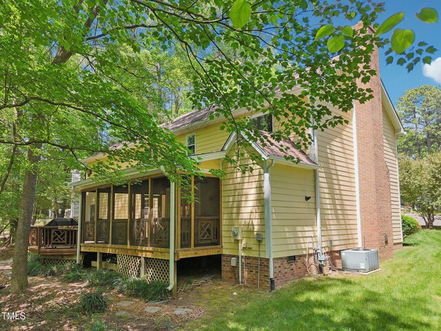 back of property featuring central AC, crawl space, a yard, a chimney, and a sunroom
