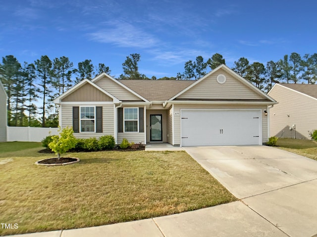 ranch-style house featuring a front lawn, driveway, an attached garage, and fence