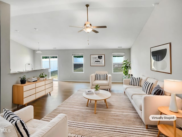 living room featuring a wealth of natural light, baseboards, wood finished floors, and a ceiling fan