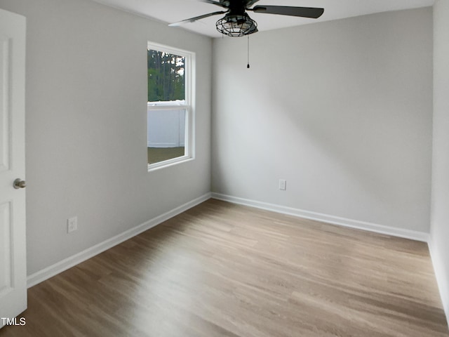 spare room with baseboards, ceiling fan, and wood finished floors