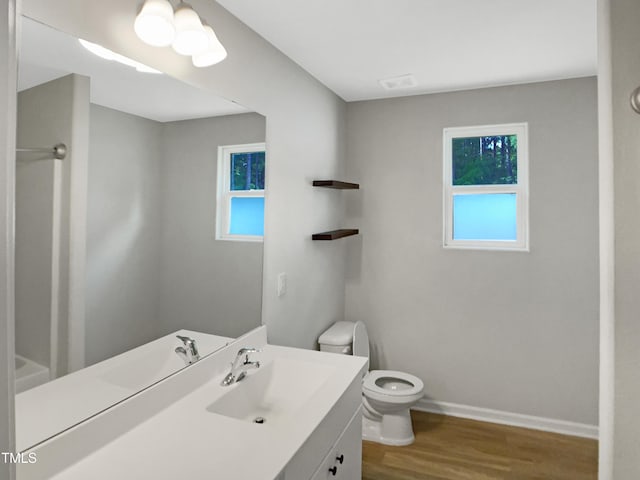 full bath featuring toilet, baseboards, visible vents, vanity, and wood finished floors