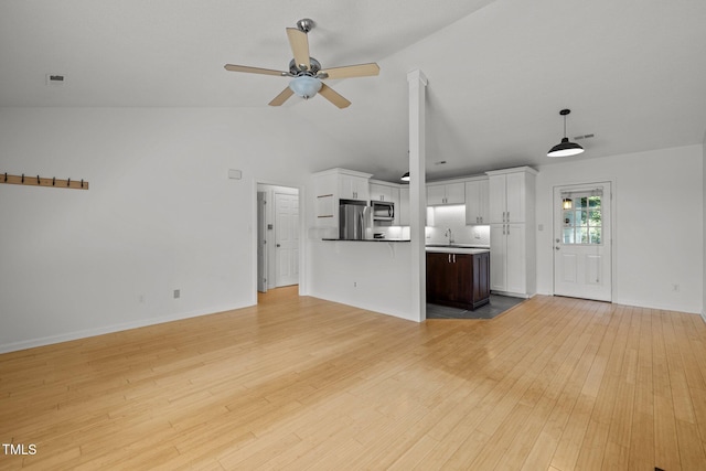 unfurnished living room featuring a ceiling fan, light wood finished floors, high vaulted ceiling, baseboards, and a sink
