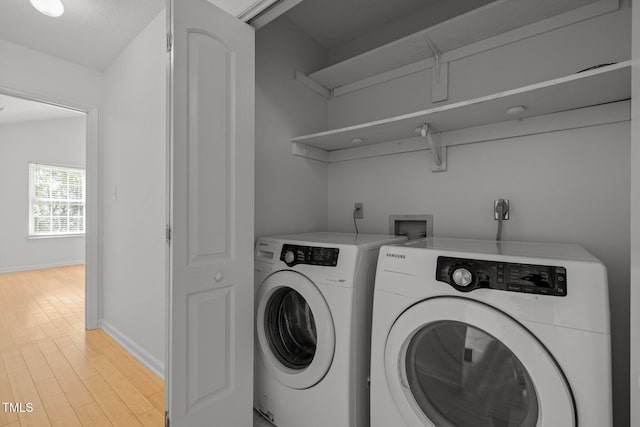 laundry area with washer and dryer, baseboards, and light wood-style flooring