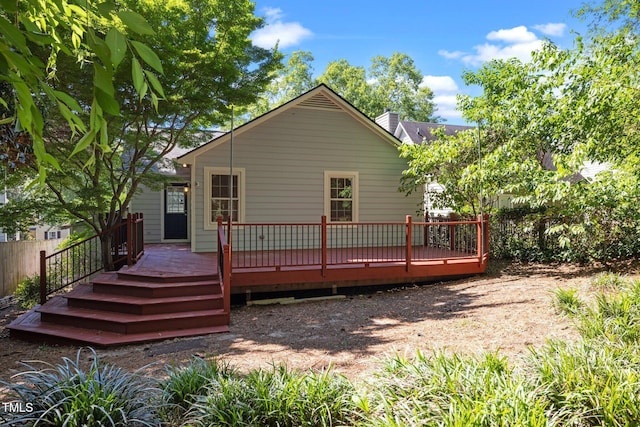 rear view of property featuring a wooden deck and fence