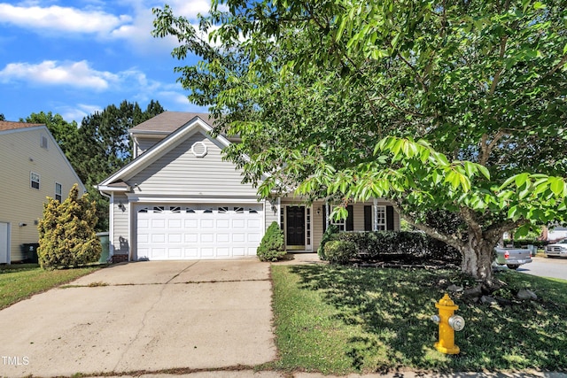 view of property hidden behind natural elements featuring a garage, concrete driveway, and a front yard