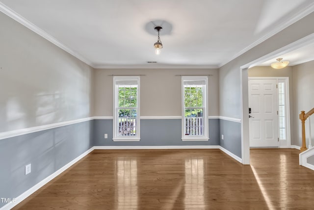 spare room with wood finished floors, baseboards, ornamental molding, and stairs