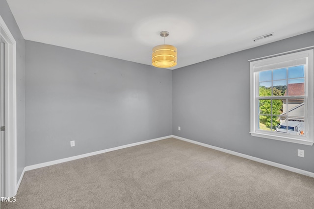 empty room featuring carpet and baseboards