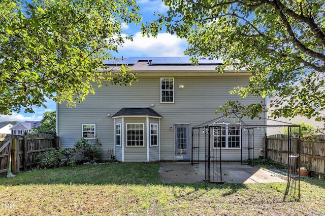 rear view of house featuring solar panels, a gazebo, and a patio
