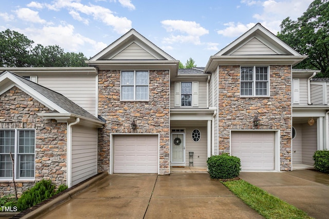 view of front facade with stone siding, concrete driveway, and a garage
