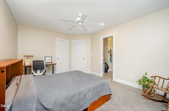 bedroom featuring baseboards, light colored carpet, and a ceiling fan